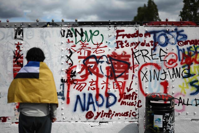 <p>Graffiti written and over-written is seen on a white-washed wall in the Brick Lane area of east London</p>