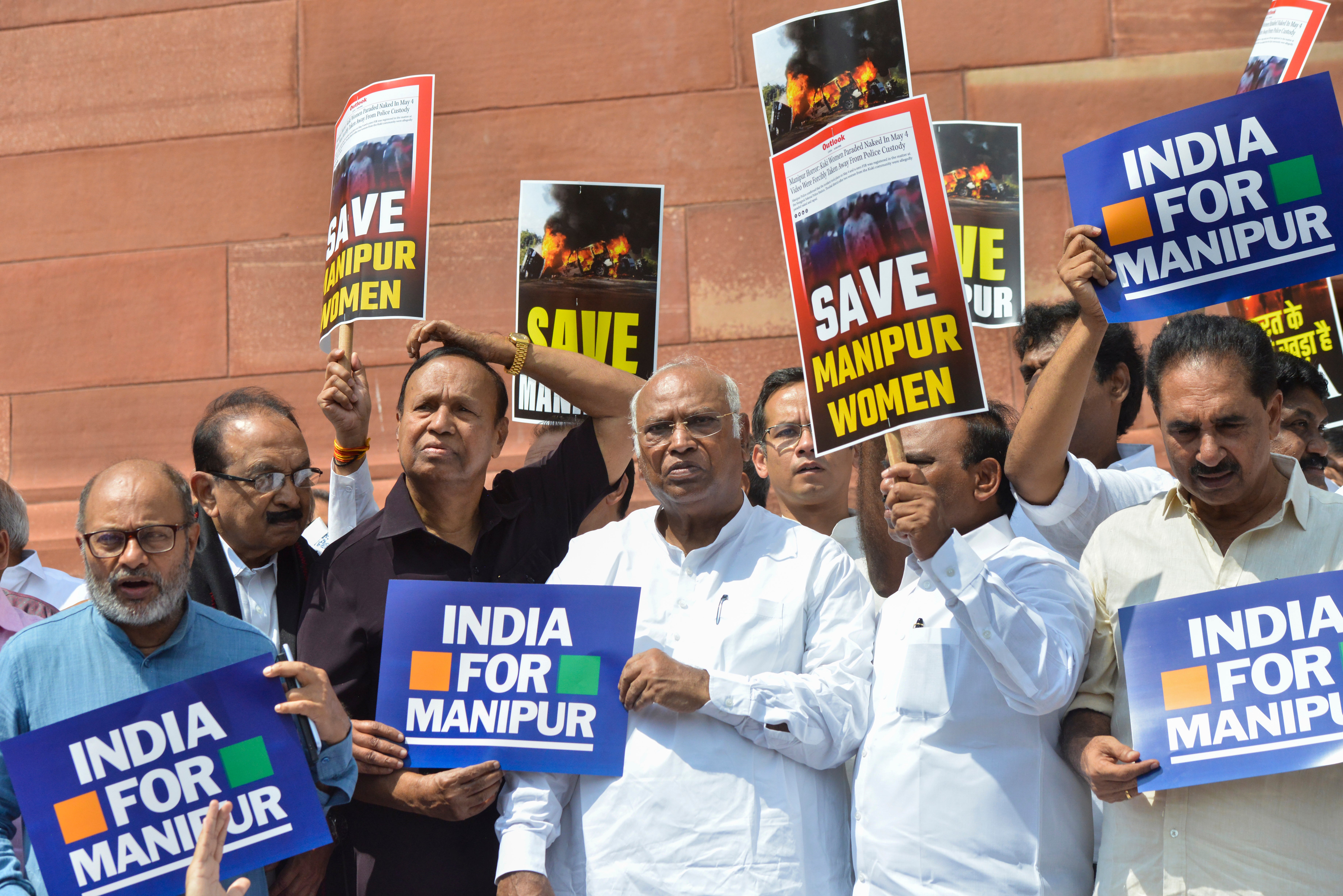 Opposition lawmakers demanding a statement from Prime Minister Narendra Modi on the violence in Manipur state carry placards outside the Parliament building in New Delhi