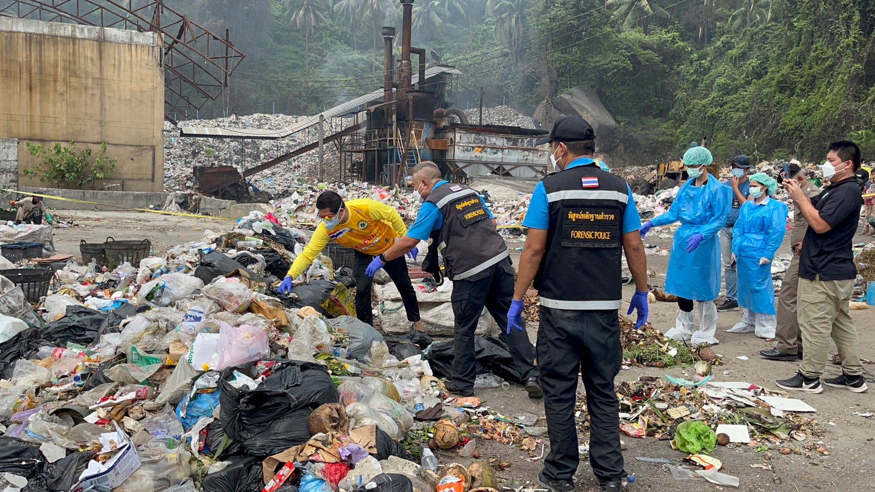 Thai police forensic officers investigate a garbage dump site as they search for parts of the body of a Colombian surgeon in Koh Phagnan island, southern Thailand