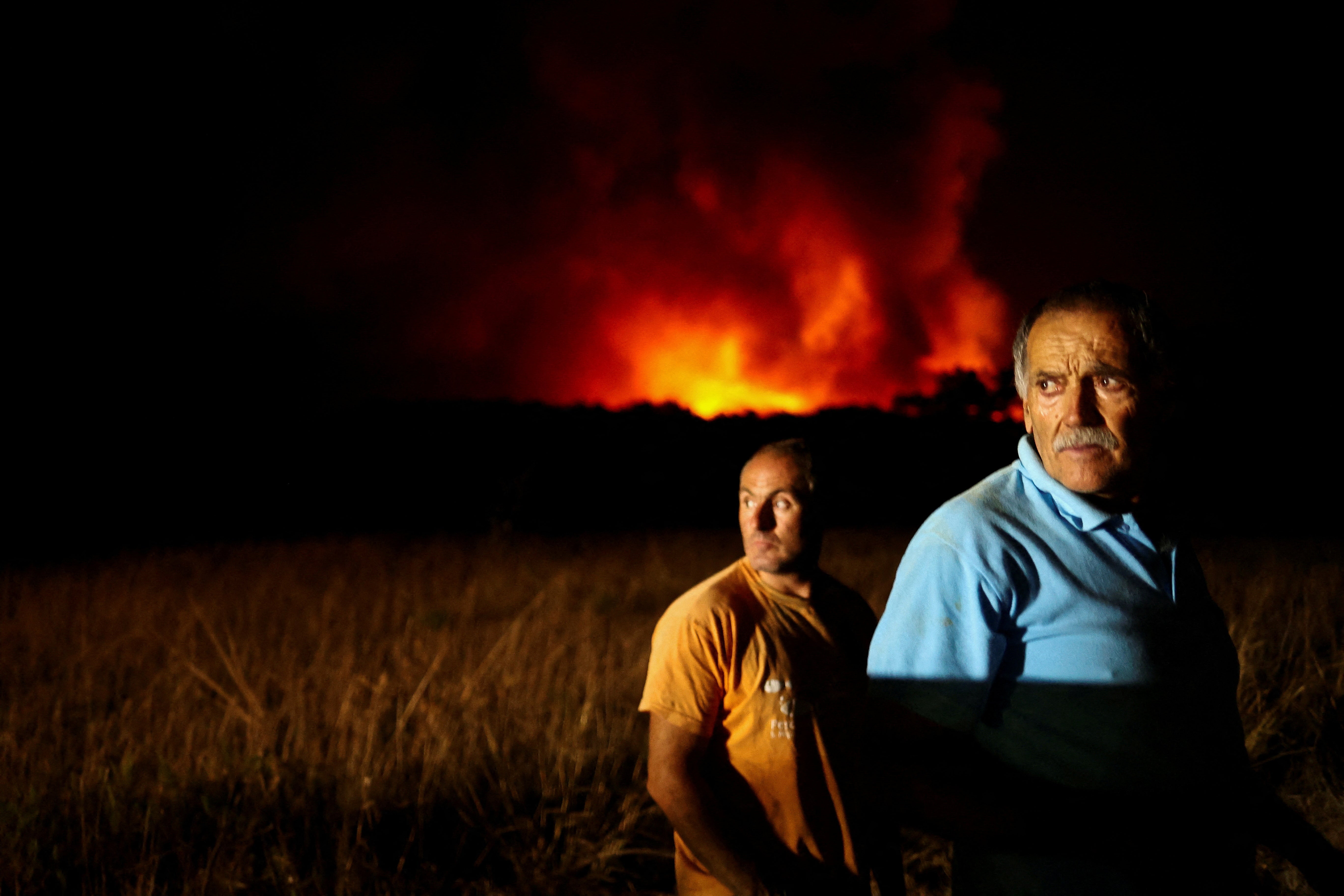 People watch a wildfire in Aljezur, Portugal