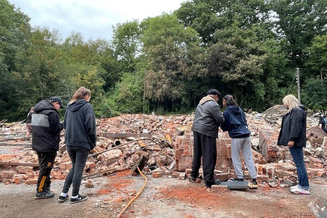 People inspect the rubble remains of The Crooked House pub (Matthew Cooper/PA)