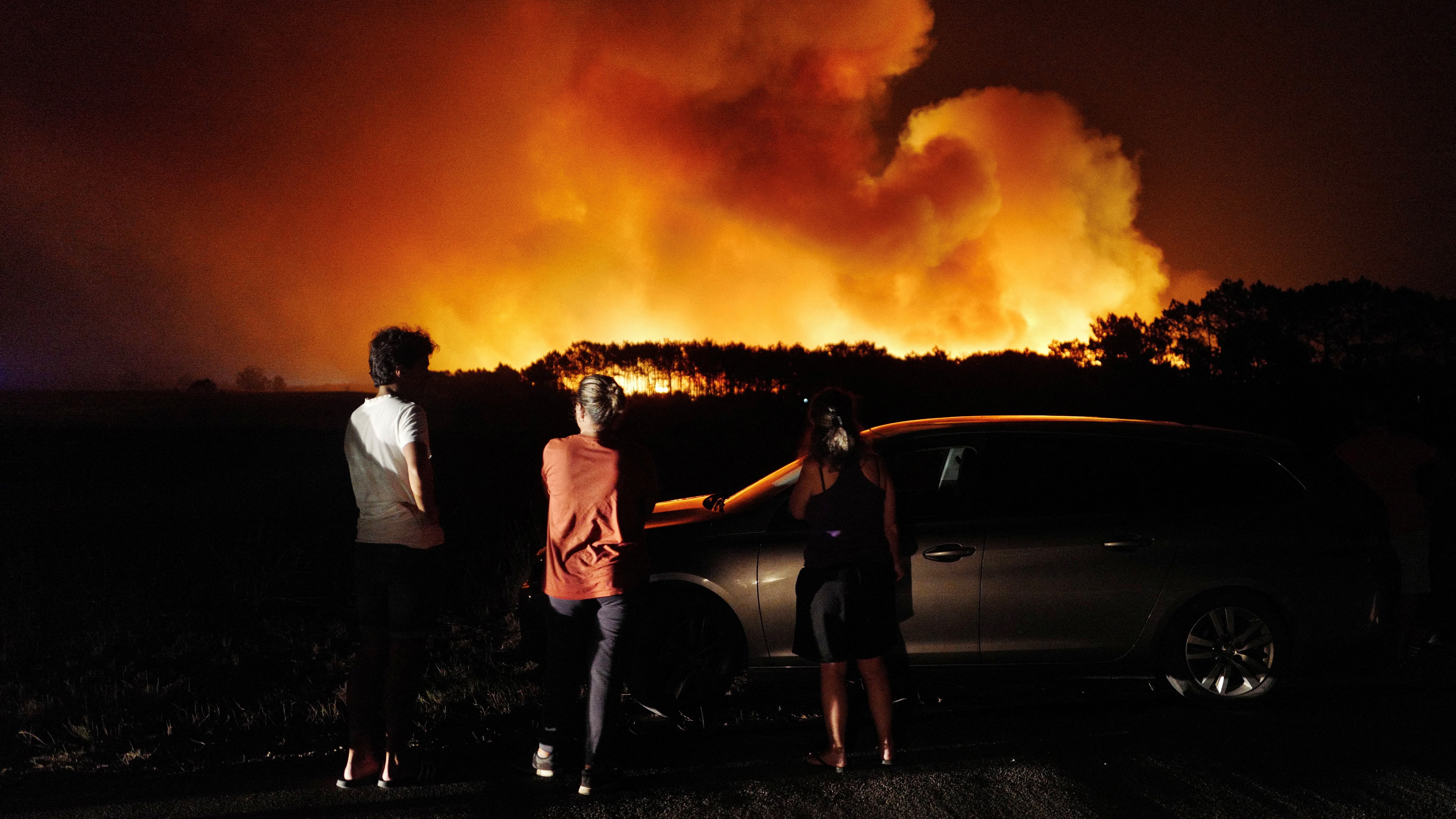 People watch a wildfire in Aljesur, Portugal, 7 August