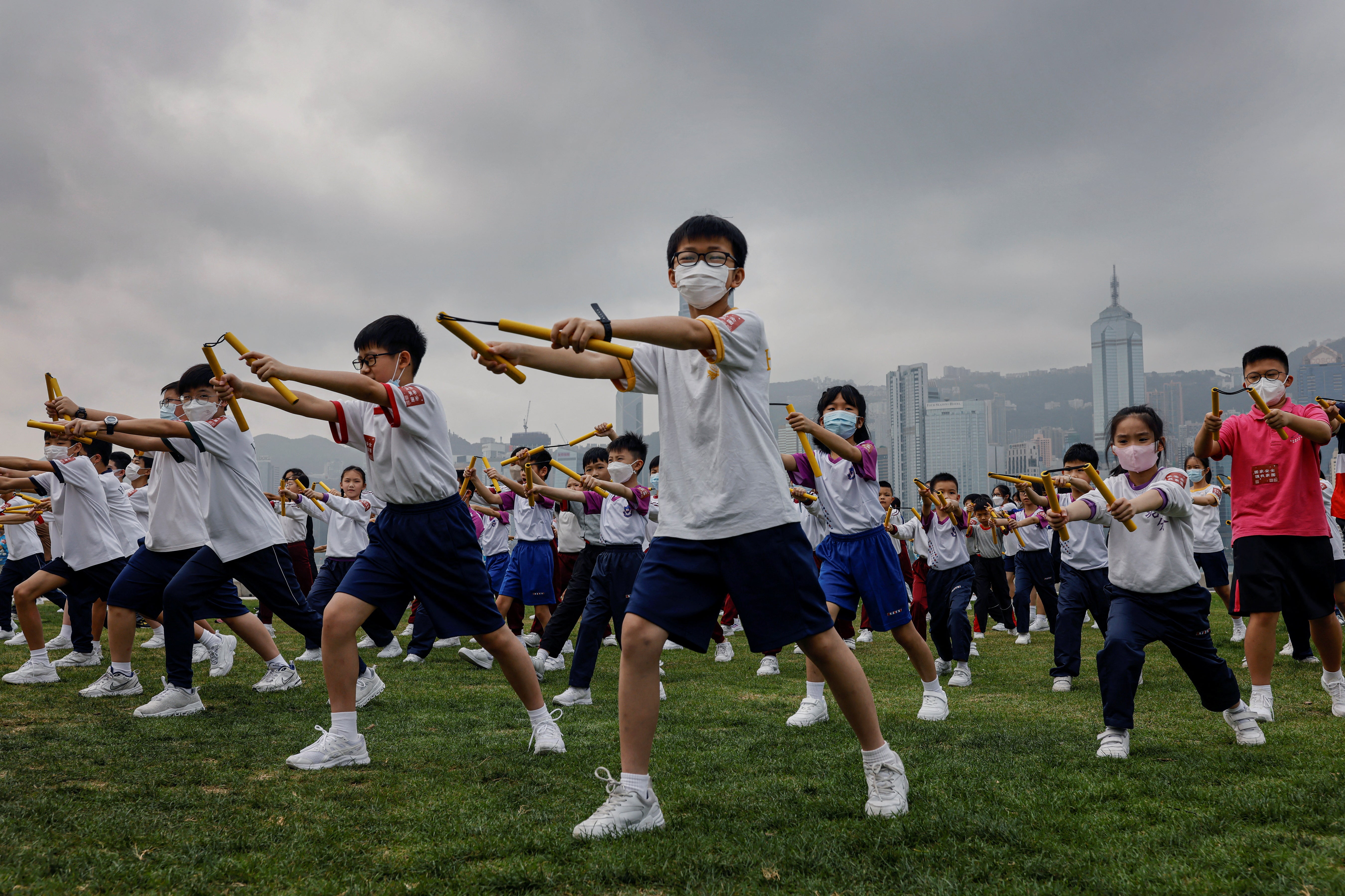 Heung Yee Kuk Yuen Long district secondary school students attend a nunchaku performance event by the sea, in a tribute to Bruce Lee in Hong Kong