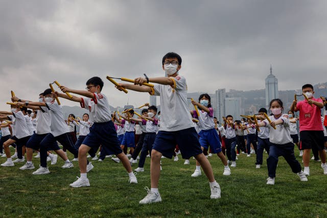<p>Heung Yee Kuk Yuen Long district secondary school students attend a nunchaku performance event by the sea, in a tribute to Bruce Lee in Hong Kong</p>