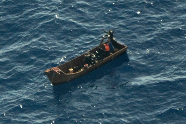 <p>Four survivors of the shipwreck wave for help</p>