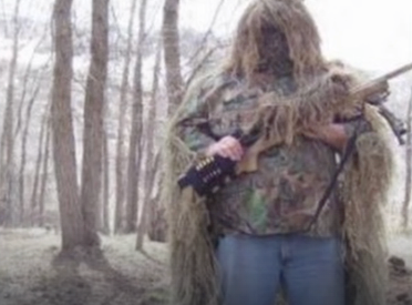 Robertson stands in camouflage holding a rifle in an undated social media photo