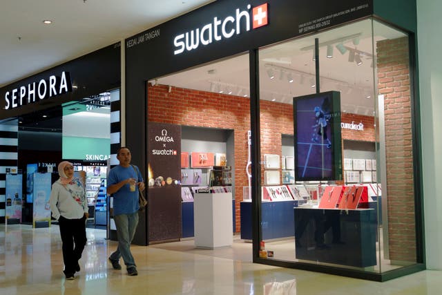 <p>A Malay couple walking pass Swatch outlet at a shopping mall in Putrajaya, Malaysia</p>