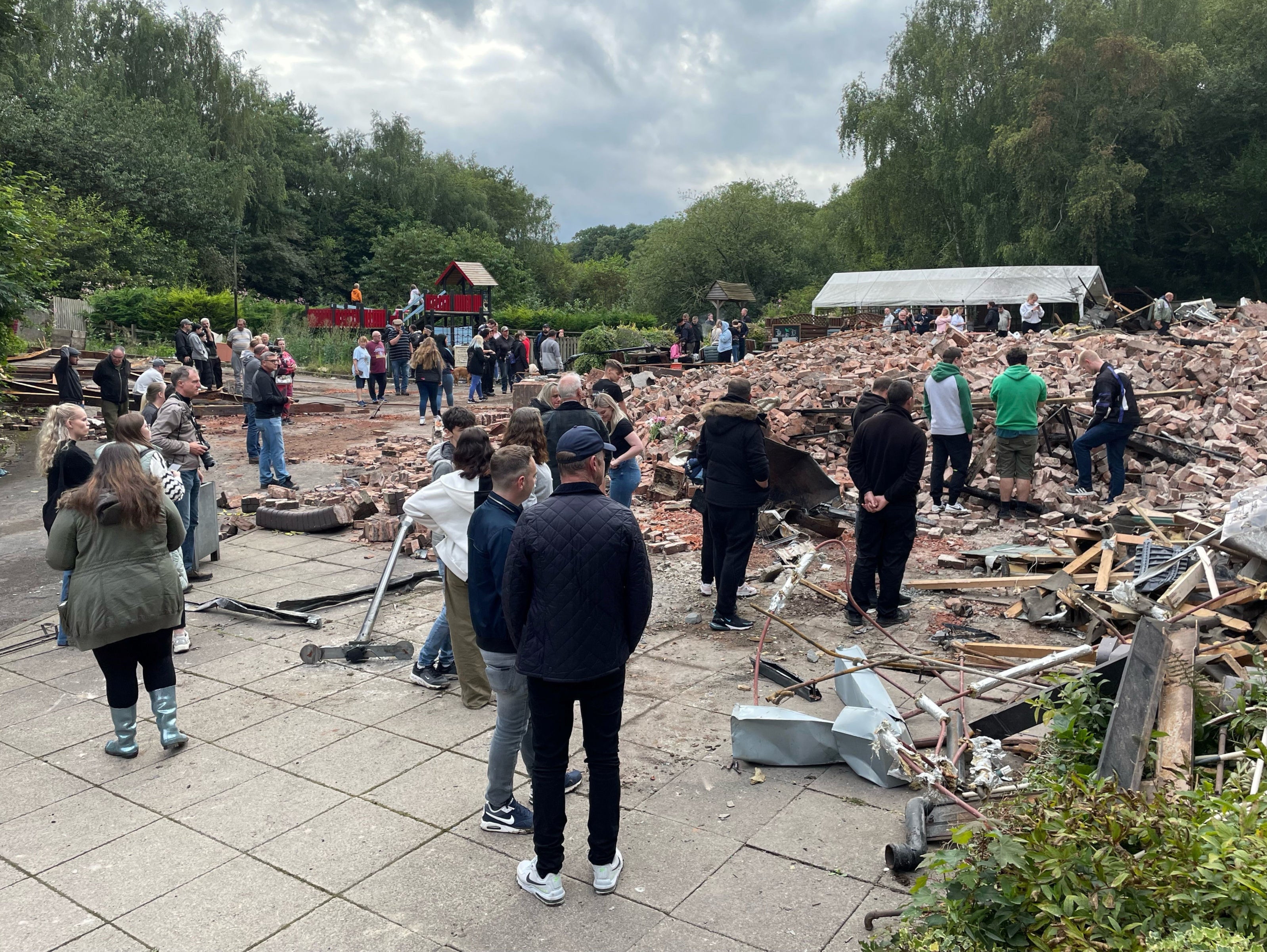 People inspect the rubble and remains of the former pub