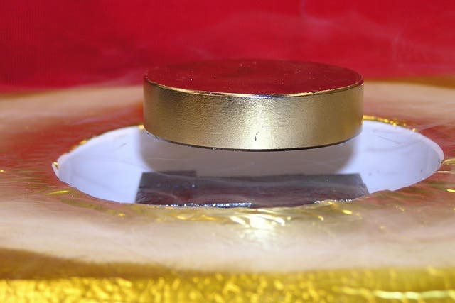 <p>Magnet levitated over a high-temperature superconductor array shows rectangular TFMs (black) levitating a heavy ferromagnet (silver) above a container of liquid nitrogen</p>