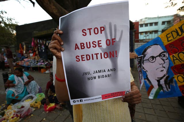 <p>File photo: A woman holds a placard protesting against the sedition case filed by police against a school after a play performed by students denouncing a new citizenship law, in Bangalore in 2020 </p>