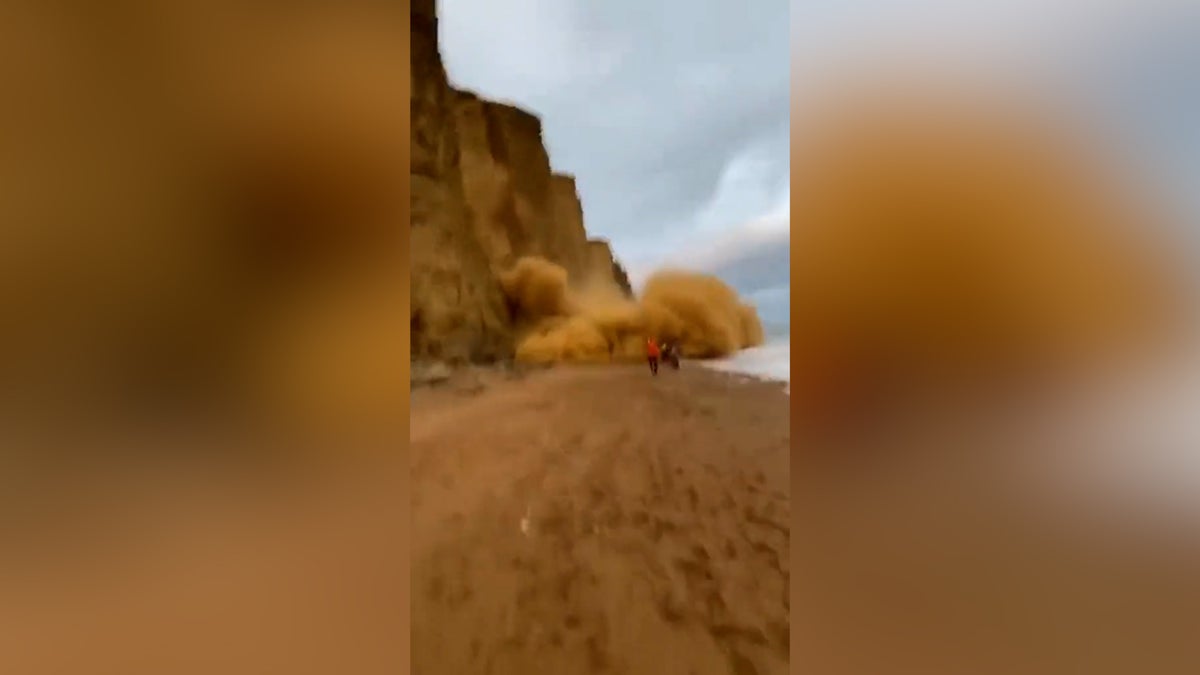 Dramatic moment beachgoers cheat death as tons of rock plummet to the beach