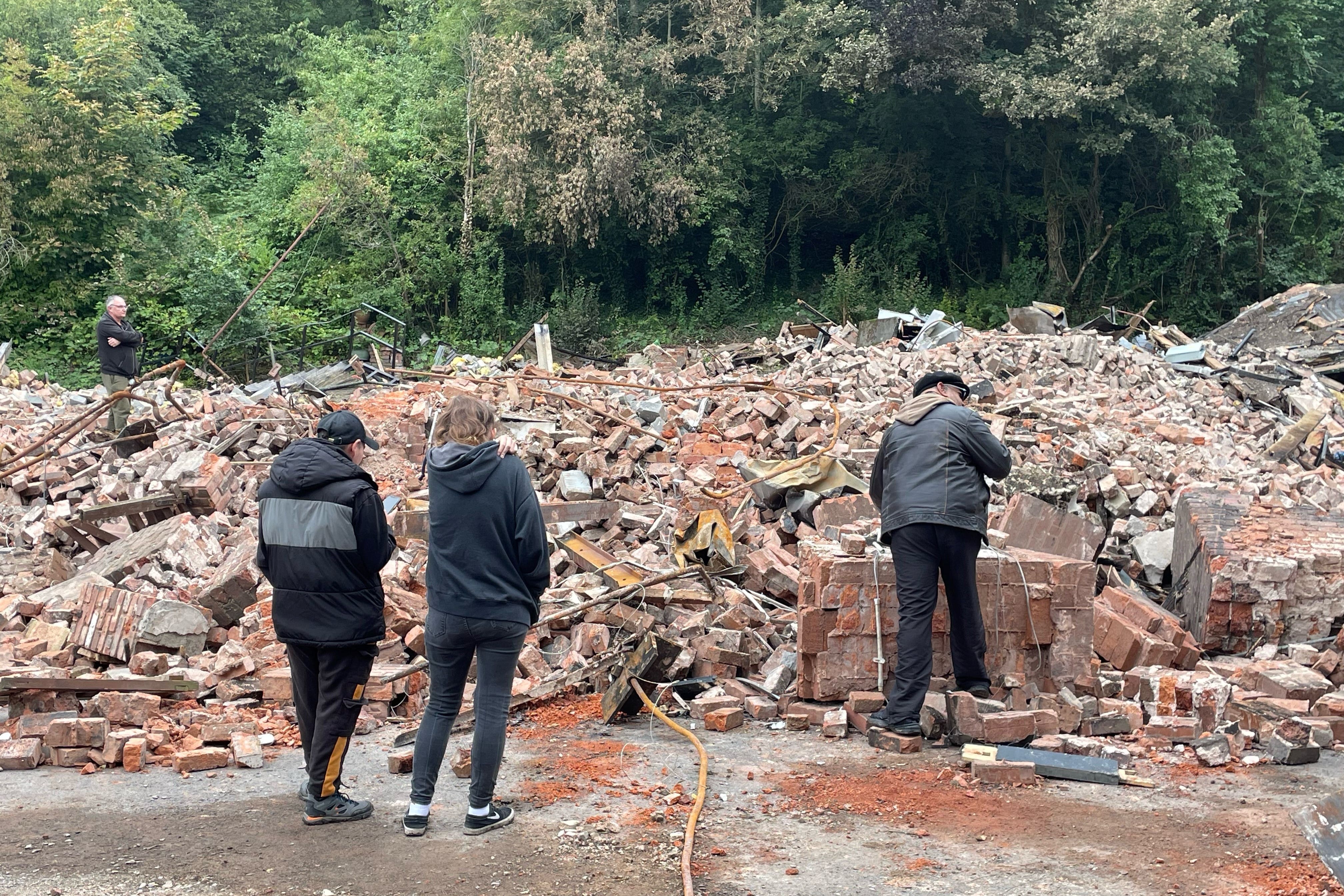 People inspect the rubble remains of The Crooked House pub in Himley