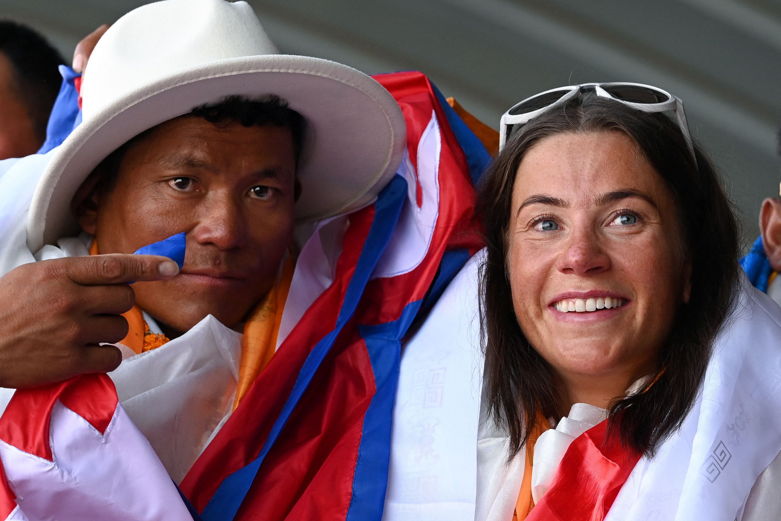 Kristin Harila, right, and Nepali guide Tenjin Sherpa gesture upon their arrival at the Tribhuvan international airport after climbing K2