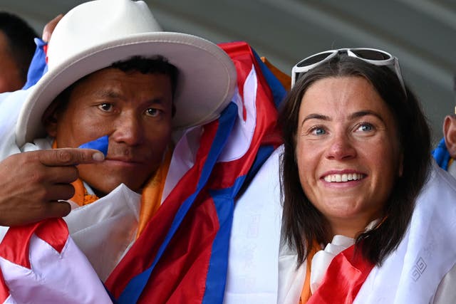 <p>Kristin Harila, right, and Nepali guide Tenjin Sherpa gesture upon their arrival at the Tribhuvan international airport after climbing K2 </p>