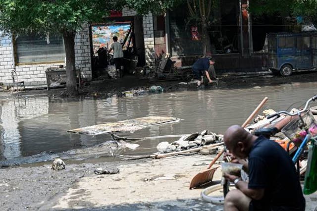 <p>Flood-affected residents clean their houses in the aftermath  of heavy rains in Zhuozhou city, in northern China’s Hebei province on 9 August 2023</p>