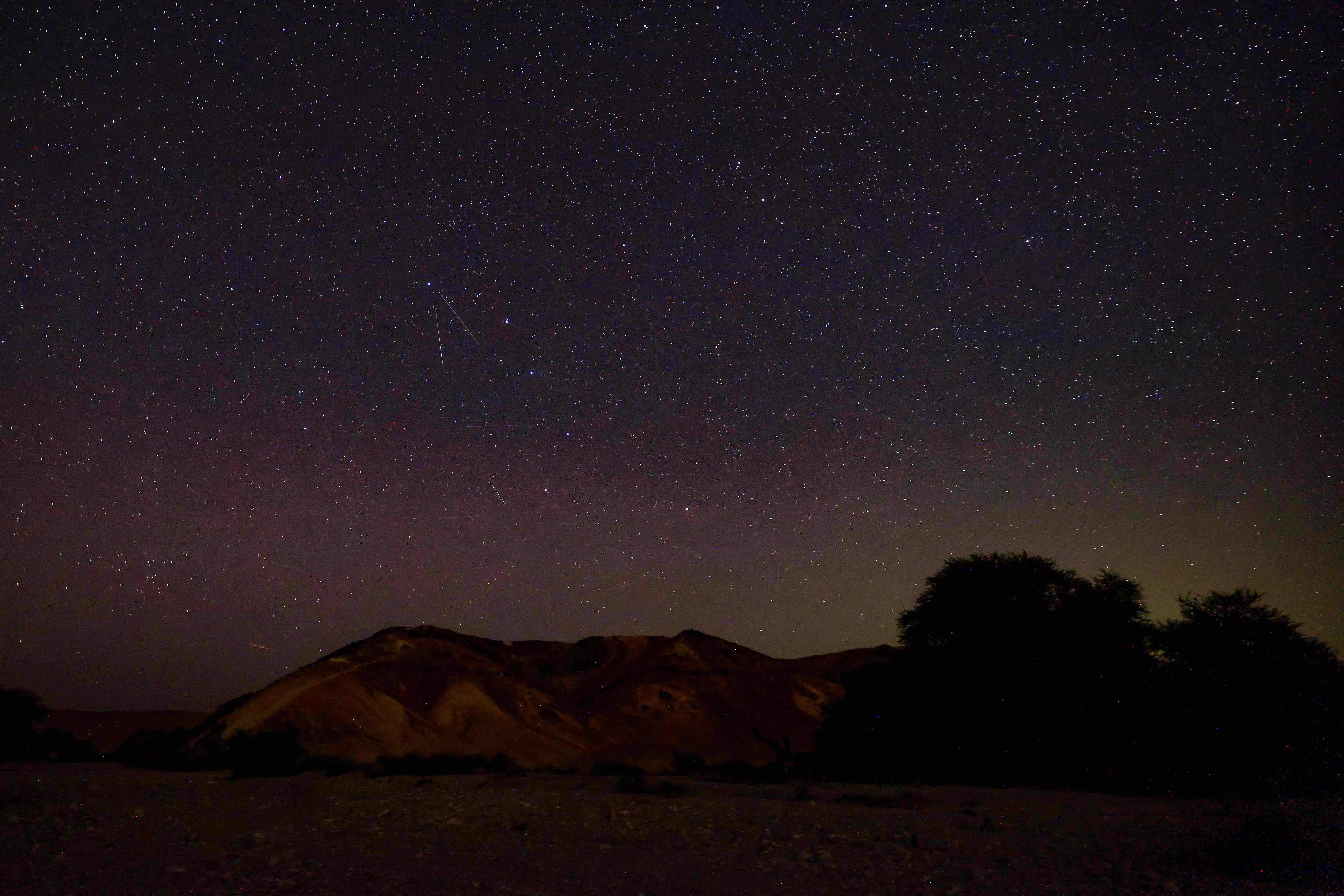 Perseid meteors streaks across the sky above a camping site in the southern israel Negev desert near the Israeli village of Faran early on 12 August 2023