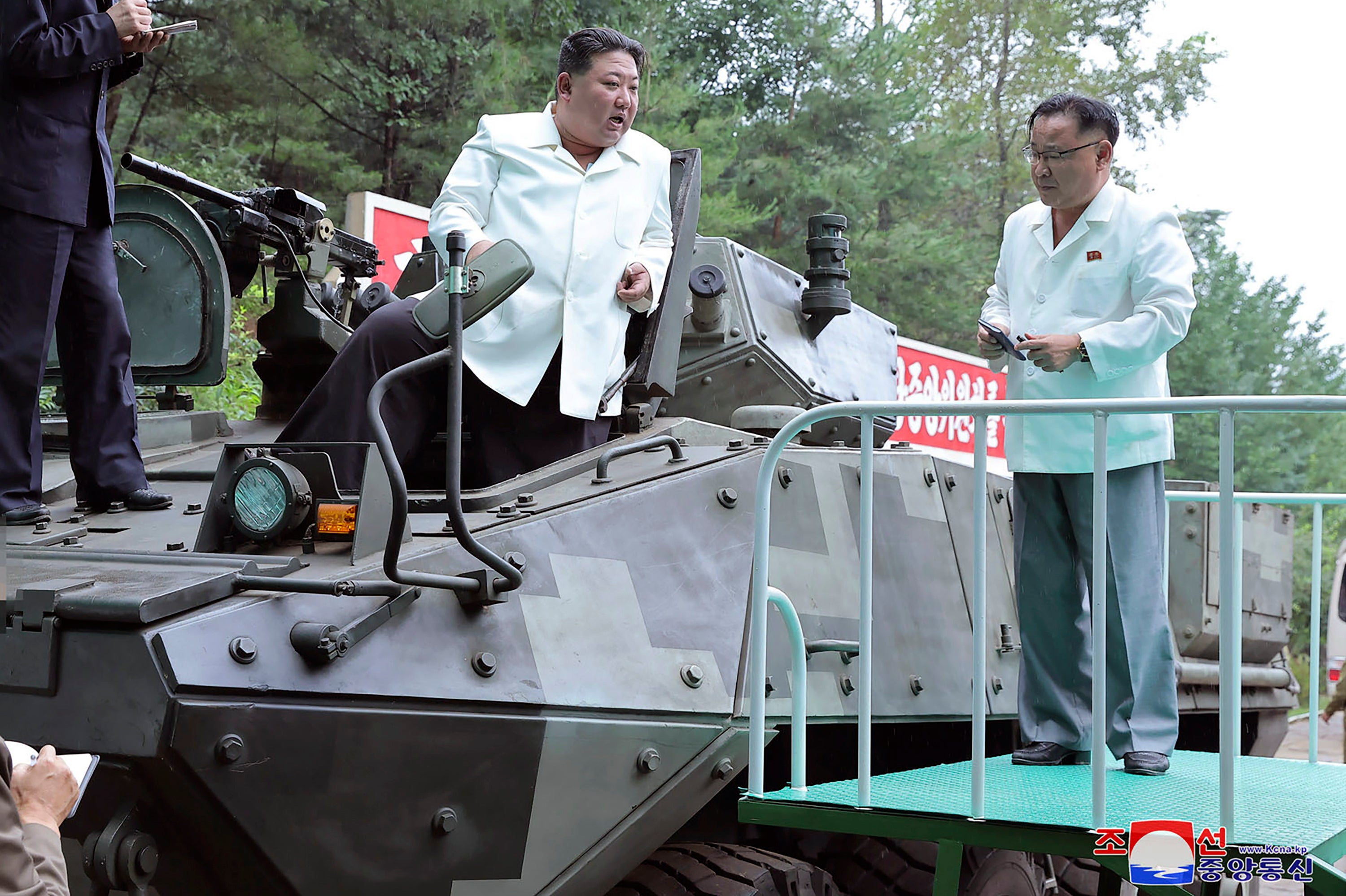 In this undated photo provided on Monday, 14 Aug 2023, by the North Korean government, North Korean leader Kim Jong-un, center, rides on an armored vehicle during his 11-12 Aug visit to a military factory in North Korea