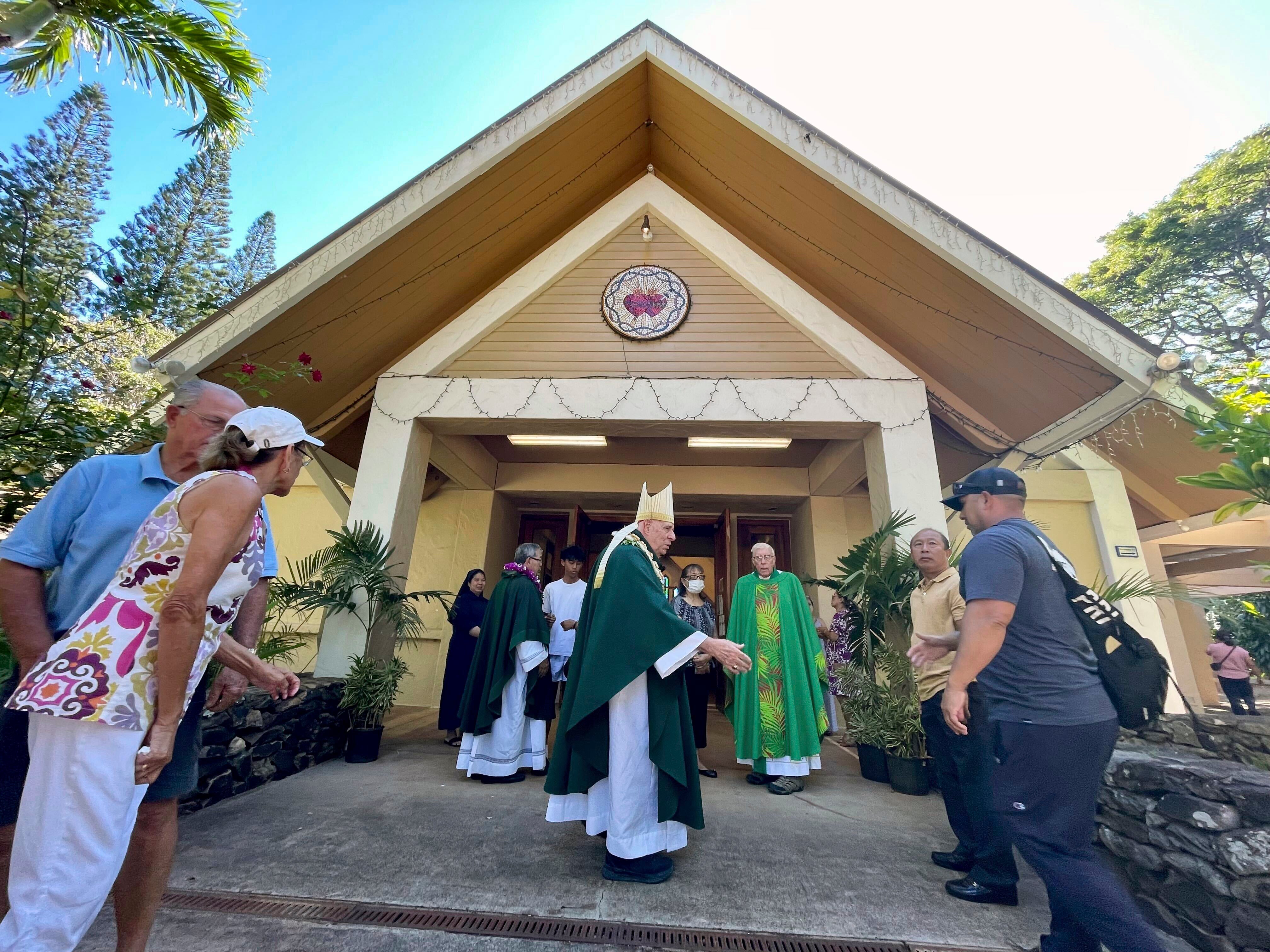 Most Rev. Clarence “Larry” Silva, the Bishop of Honolulu, greets parishioners after Mass at Sacred Hearts Mission Church on Sunday, after it was spared by wildfires