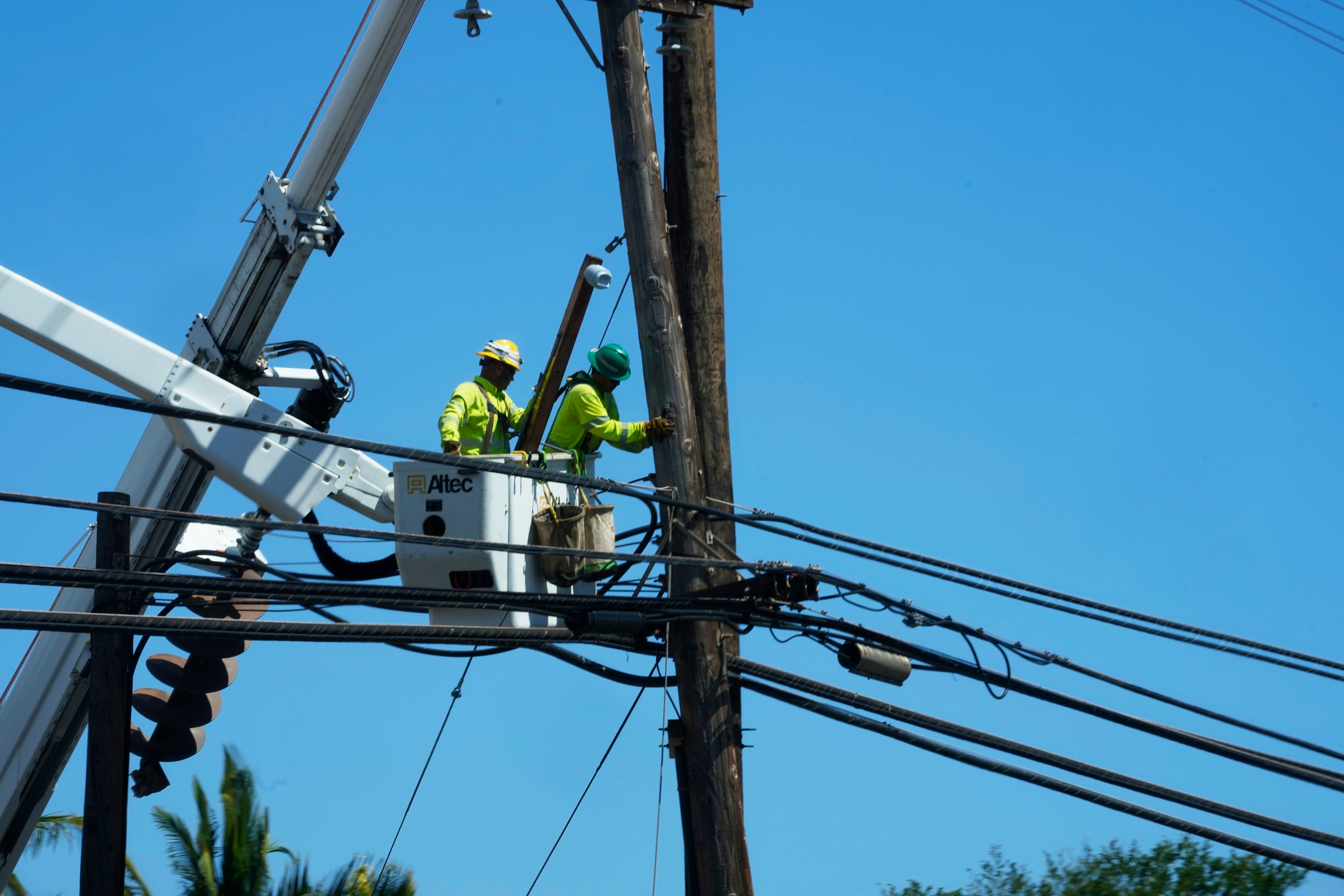 Linemen repairing damaged elecricity wires in Lahaina