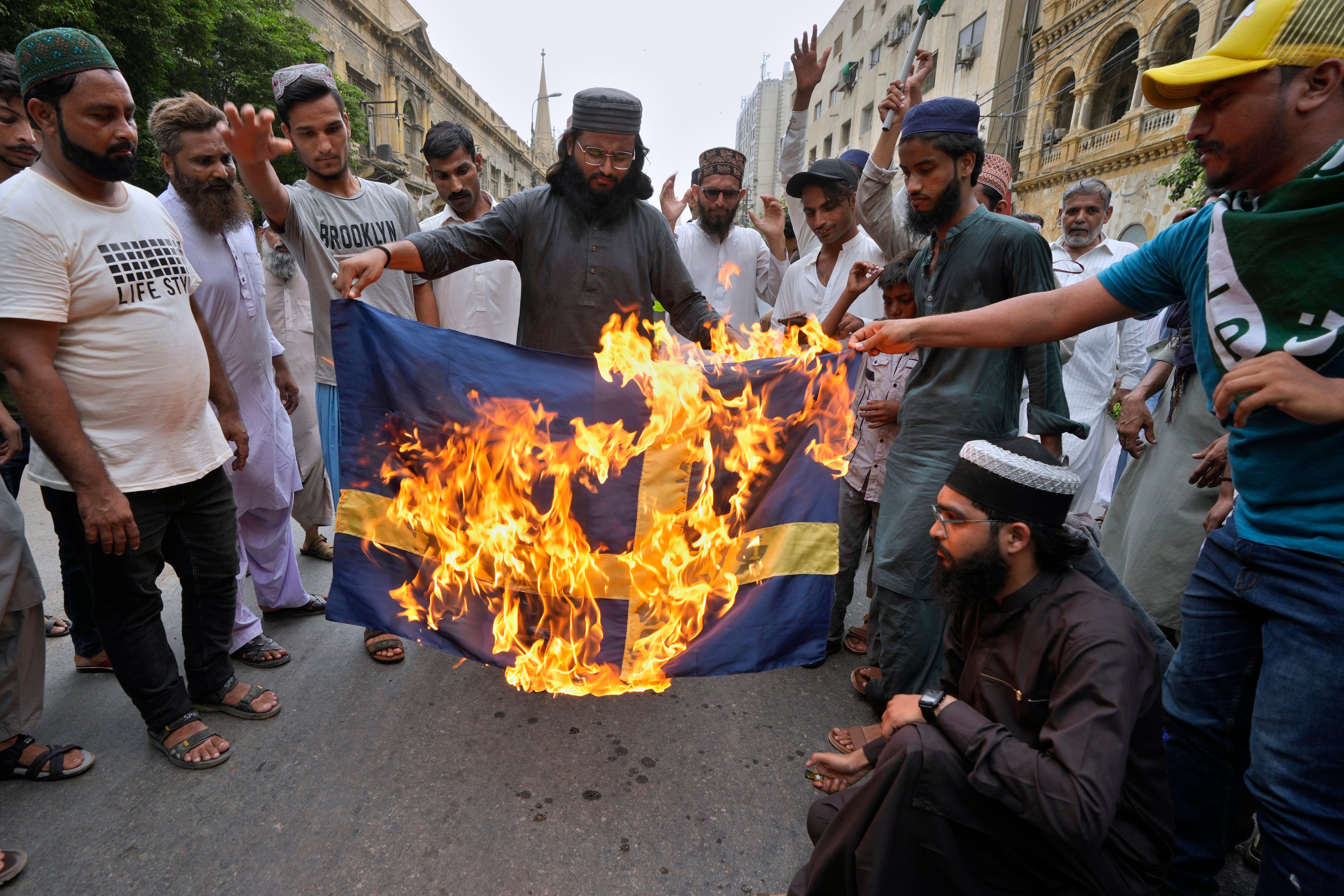 Protesters burn a Swedish flag during a protest in Karachi, Pakistan, in July