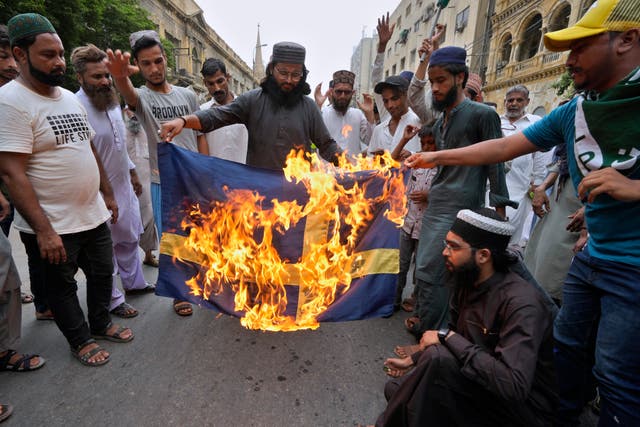<p>Protesters burn a Swedish flag during a protest in Karachi, Pakistan, in July </p>