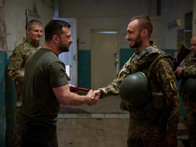 <p>Volodymyr Zelensky hands out an award to a Ukrainian serviceman as he visits the frontline near the city of Soledar in Donetsk</p>