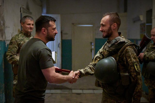 <p>Volodymyr Zelensky hands out an award to a Ukrainian serviceman as he visits the frontline near the city of Soledar in Donetsk</p>