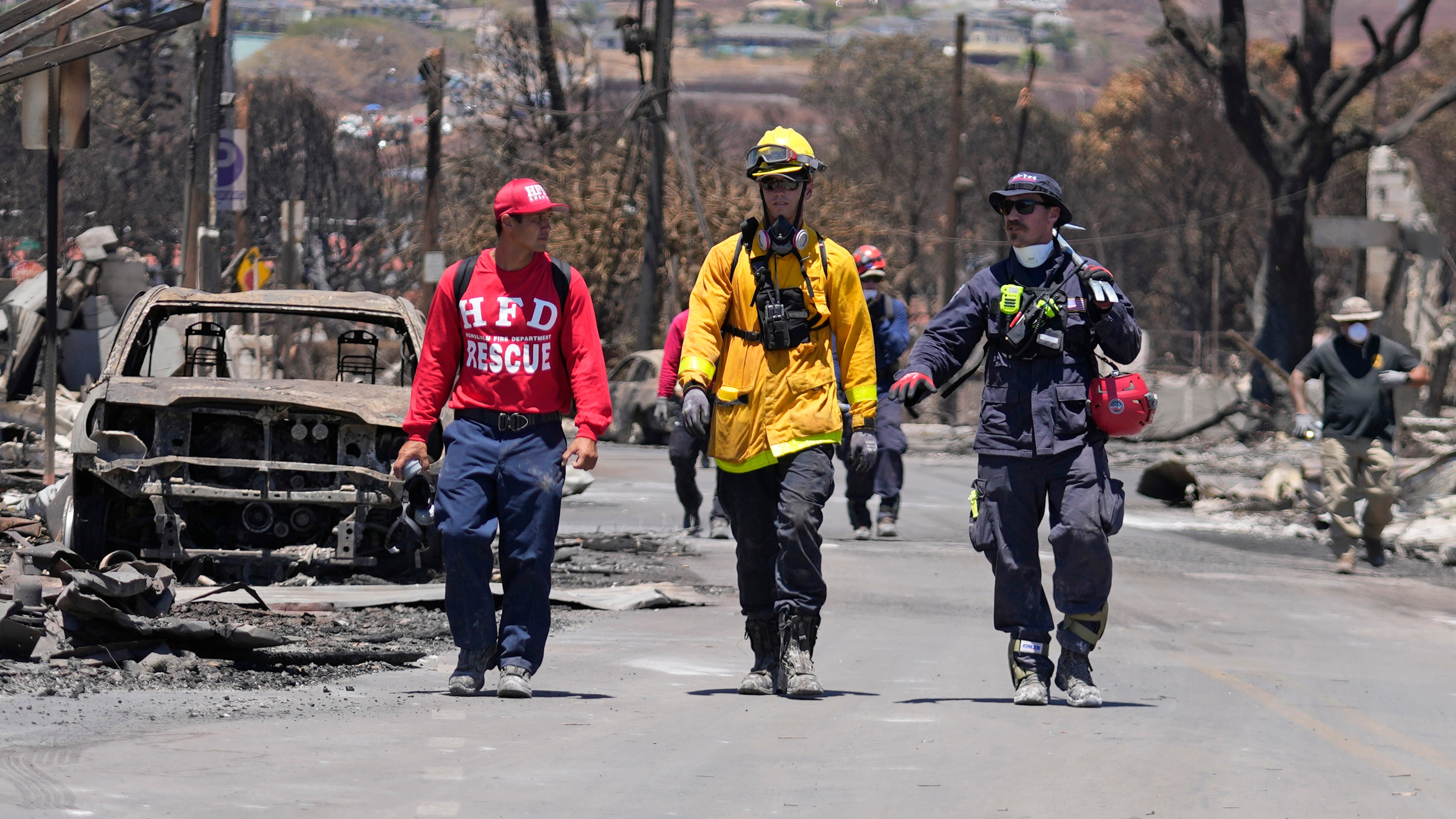 Members of a search-and-rescue team walk along a street, Saturday, Aug. 12, 2023, in Lahaina, Hawaii