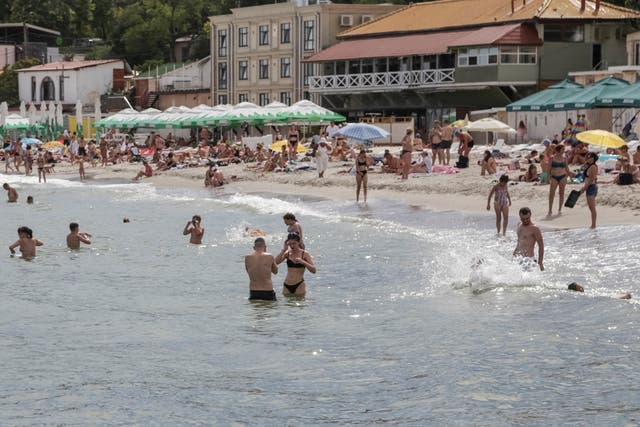 <p>People relax at a Black Sea beach that was reopened after being closed down last year following  sea mines laid around the ports of Odesa and Mykolaiv by Russia and Ukraine</p>