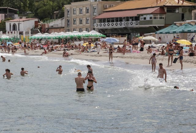 <p>People relax at a Black Sea beach that was reopened after being closed down last year following  sea mines laid around the ports of Odesa and Mykolaiv by Russia and Ukraine</p>