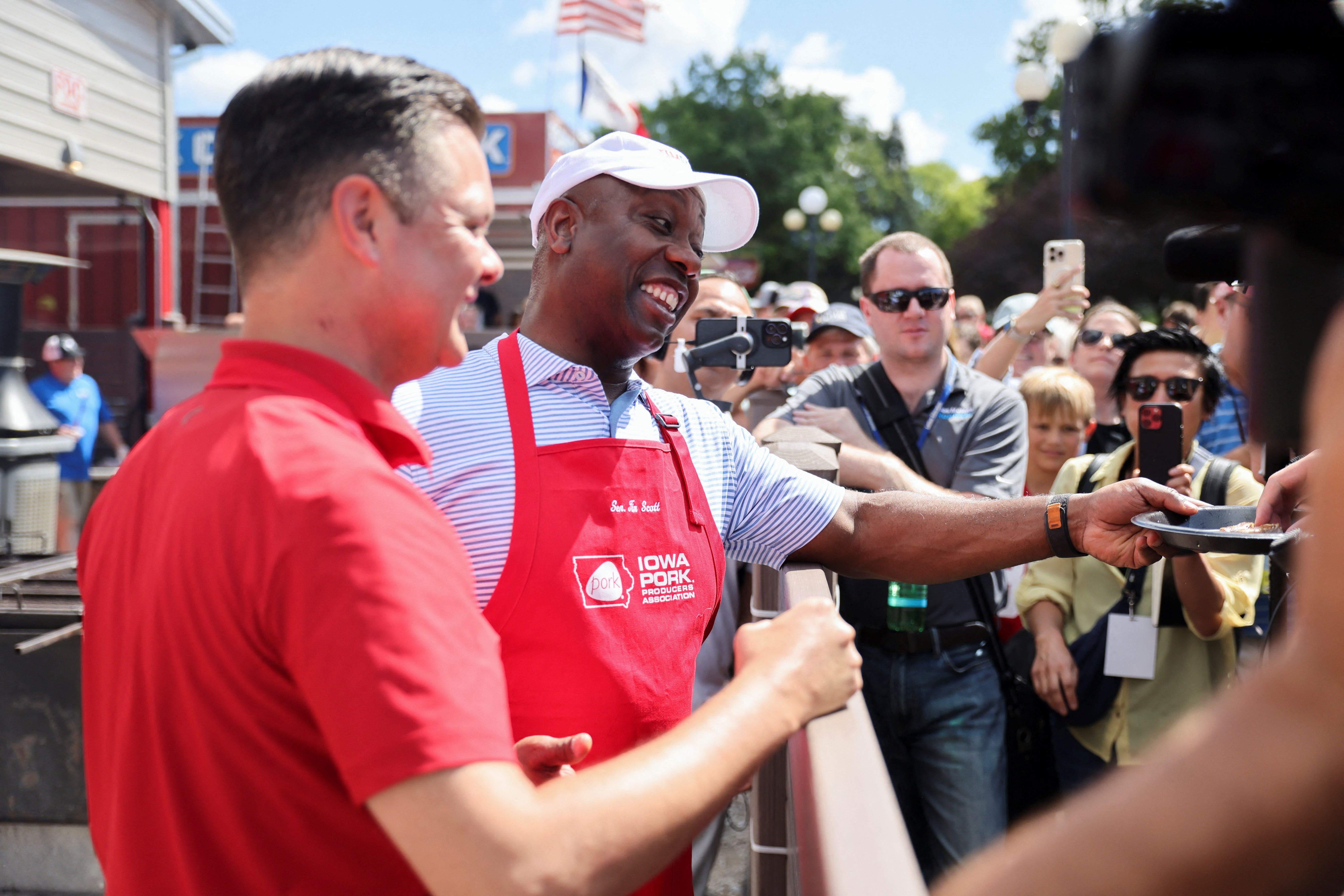 Tim Scott, second from left, hands out grilled pork chops at the Iowa State Fair