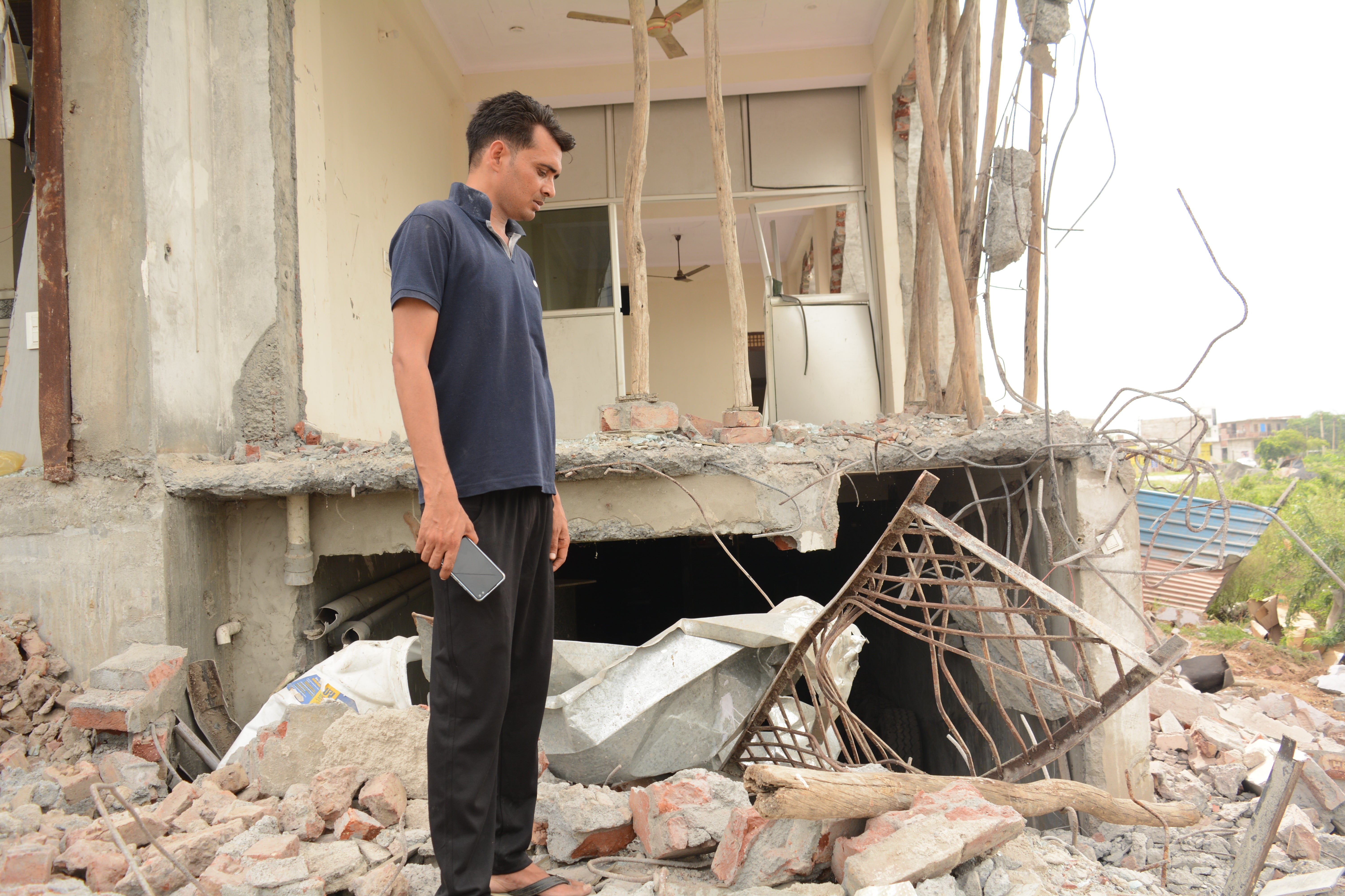 Anees Khan looking at debris of his house in Nuh that was bulldozed on 5 August 2023