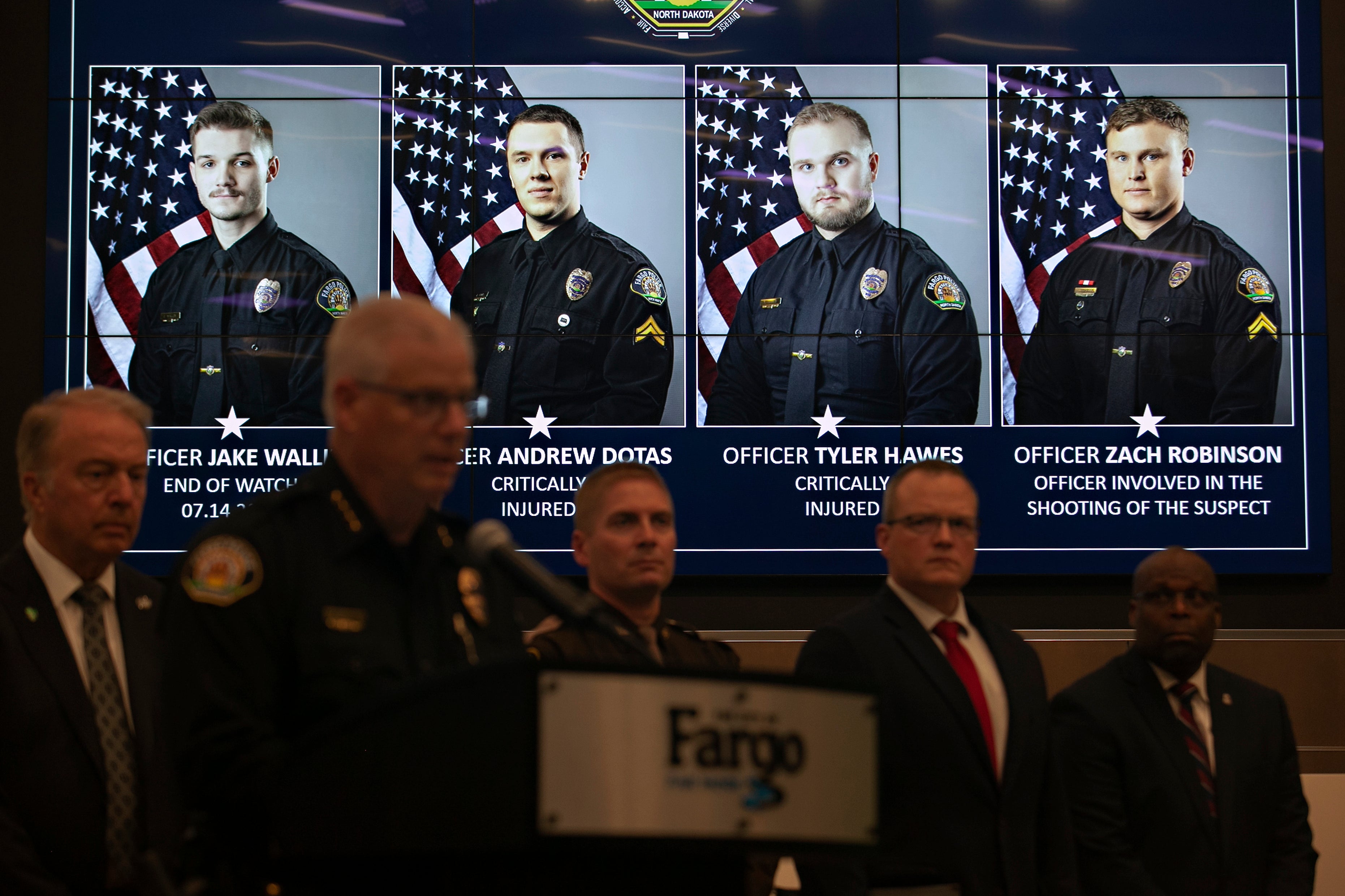 Photos of Fargo, N.D., police officers involved in a shooting are displayed during a news conference