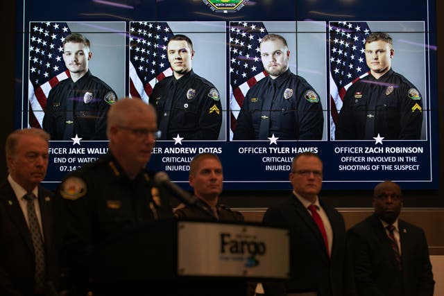 <p>Photos of Fargo, N.D., police officers involved in a shooting are displayed during a news conference</p>