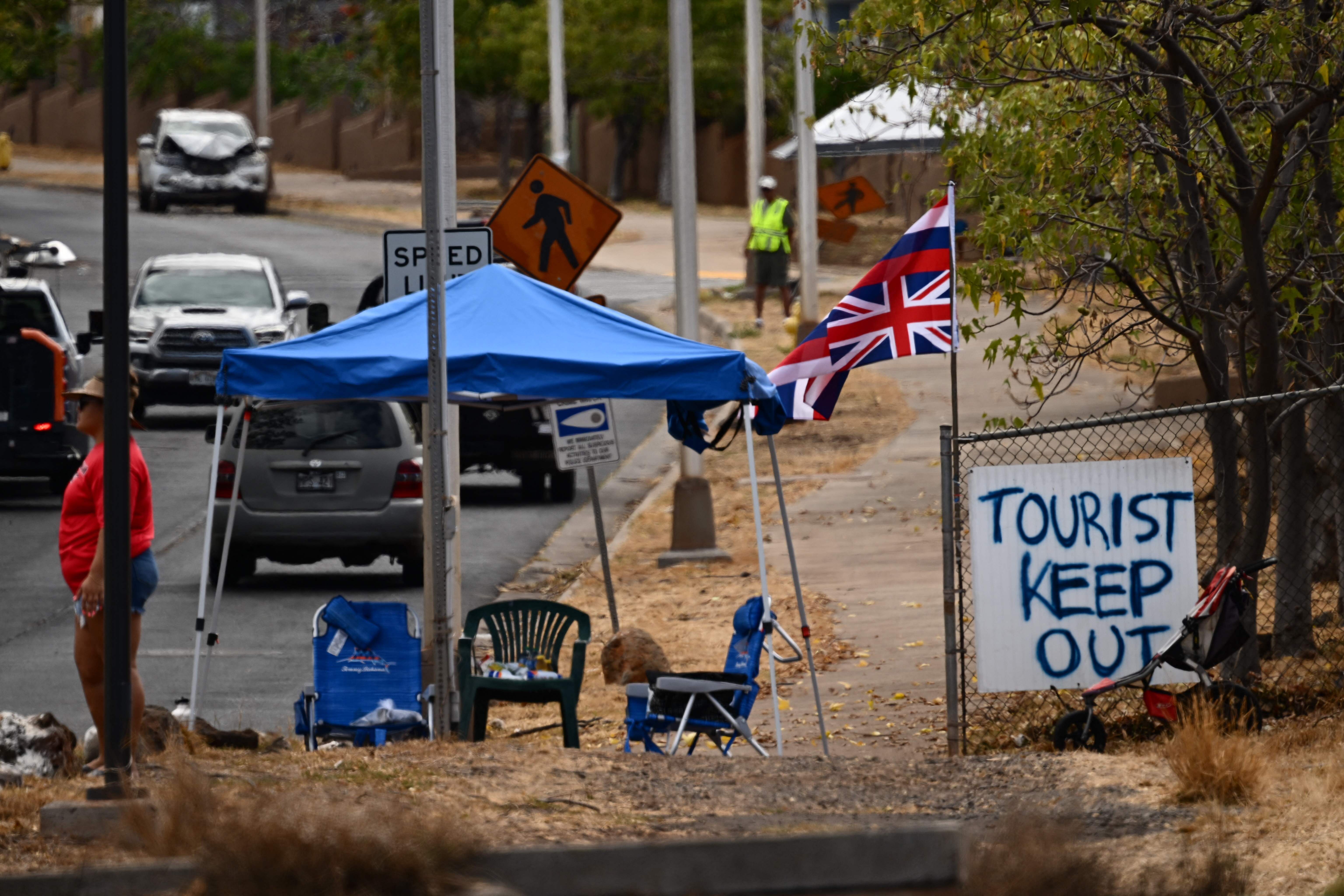 <p>The Flag of Hawaii waves by a sign reading "Tourist Keep Out" in the aftermath of the Maui wildfires in Lahaina, Hawaii, on August 16, 2023.</p>