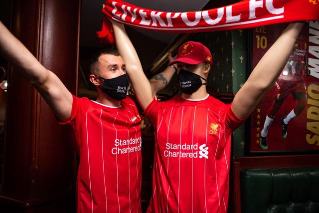 <p>A Liverpool fan poses with a manikin inside Anfield sports bar</p>