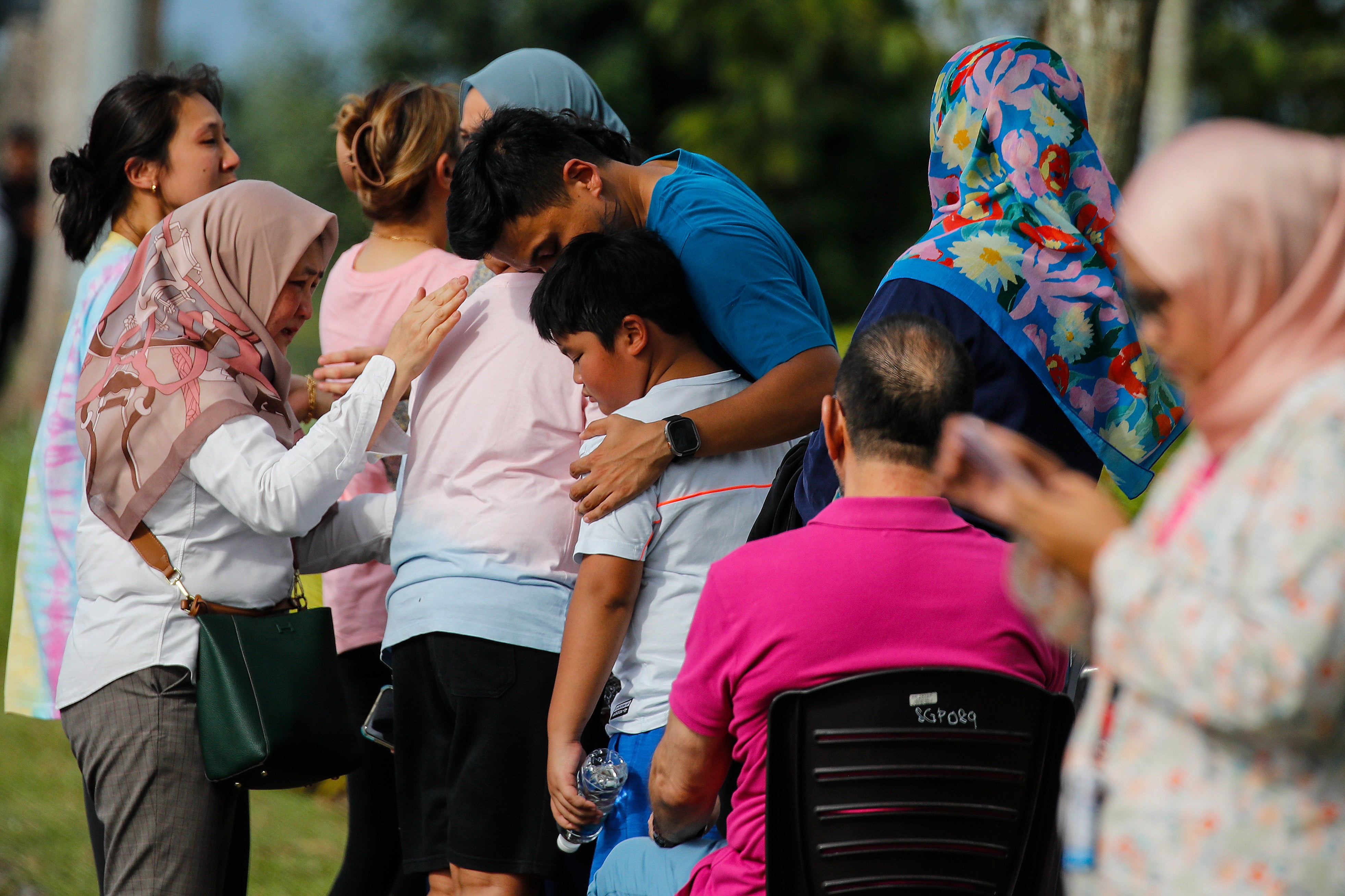 Family and relatives react at the scene of light aircraft crash in Elmina, state of Selangor, Malaysia