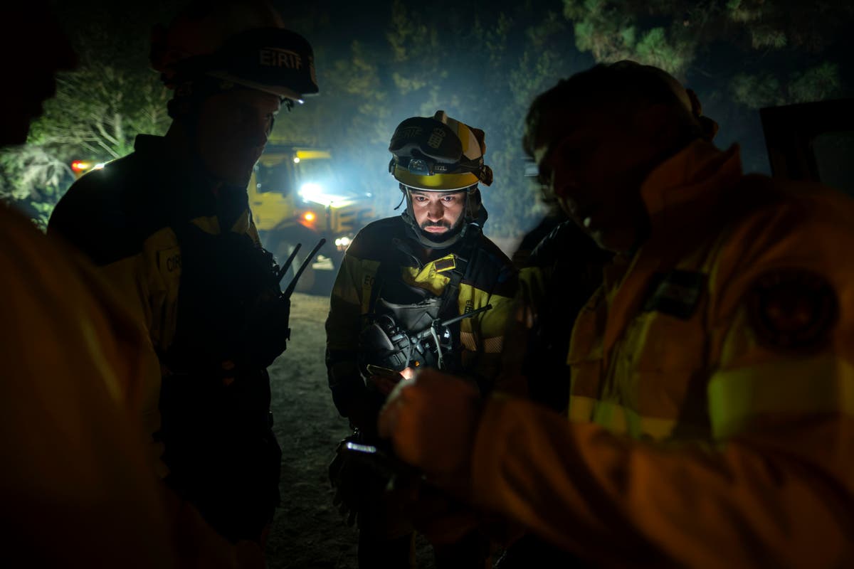 Los bomberos luchan durante la noche para detener un incendio forestal en la popular isla turística de Tenerife en España