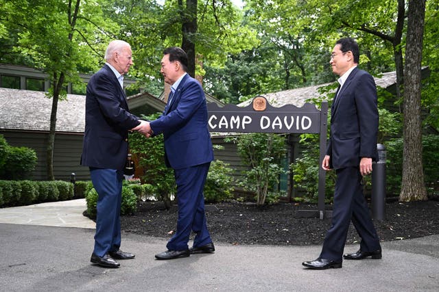 <p>President Joe Biden (L), greets Japanese Prime Minister Fumio Kishida (R), and South Korean President Yoon Suk Yeol (C) during the Camp David Trilateral Summit</p>