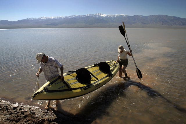 <p>Jay Shapiro (L), of Thousand Oaks, California, and Cheryl Cox, of Ventura, California come ashore after kayaking in a giant lake in the bottom of Death Valley caused by recent heavy flooding, on March 12, 2005 in Death Valley National Park, California. </p>