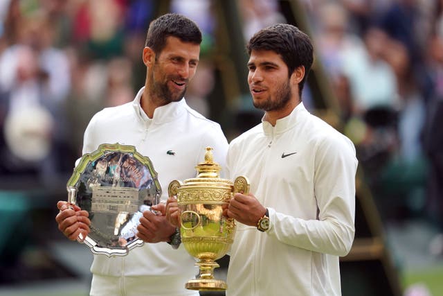Carlos Alcaraz with the Gentlemen’s Singles Trophy, alongside Novak Djokovic with the runners up plate/trophy at 2023 Wimbledon Championships (Victoria Jones/PA)