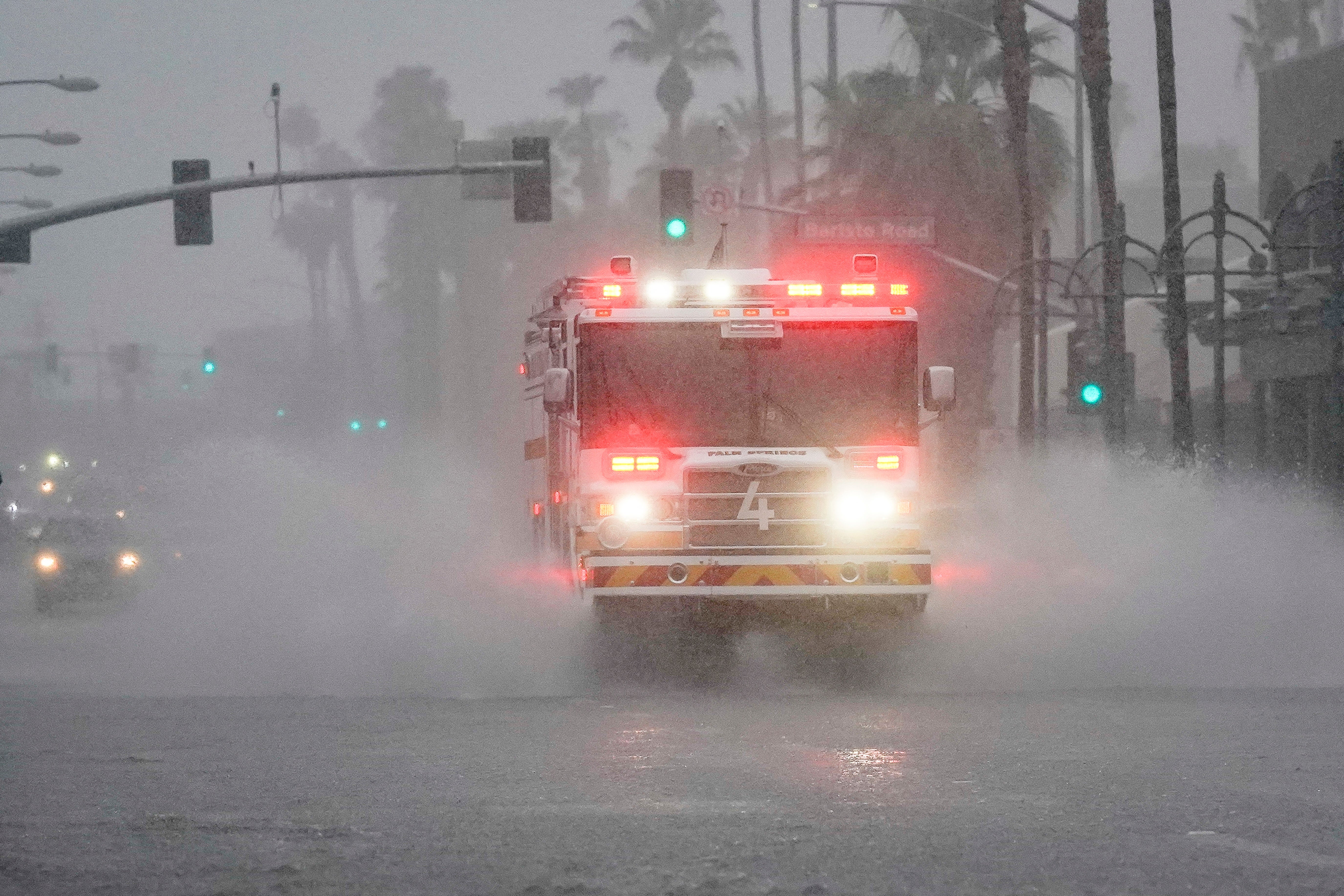 <p>A fire engine responds to a call through standing water on Indian Canyon Drive as Tropical Storm Hilary approaches Palm Springs, California</p>