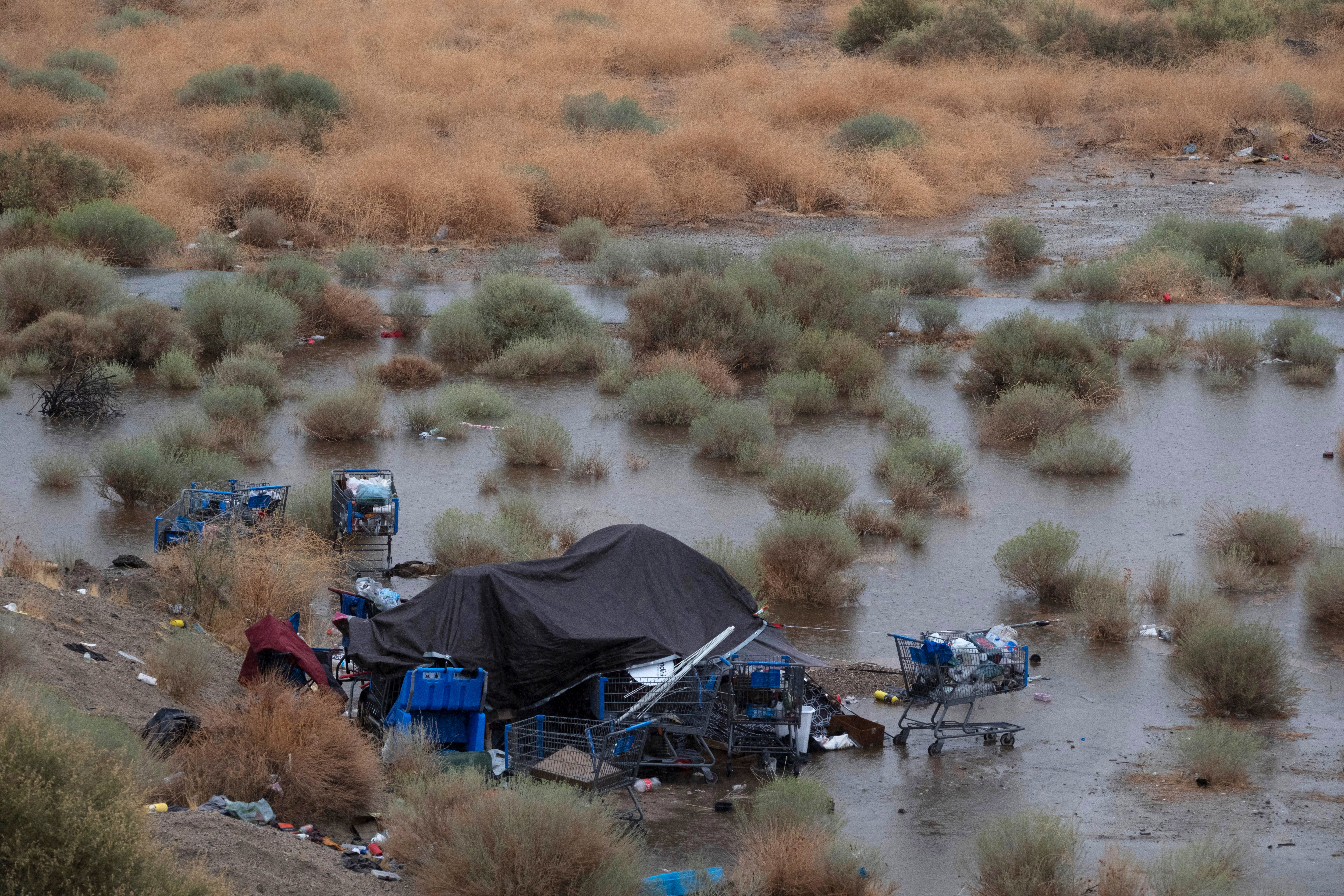 <p>A flooded homeless encampment is seen along California Route 14 in Palmdale</p>