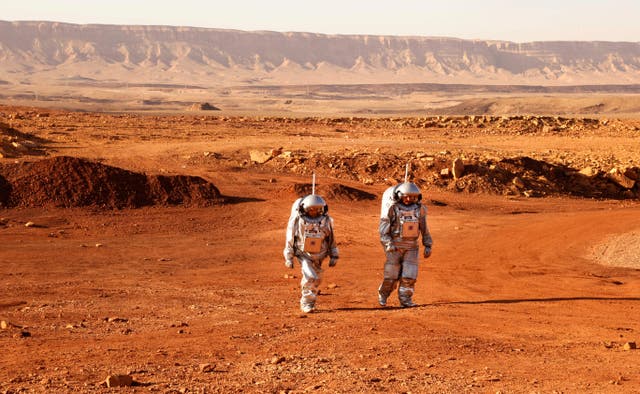 <p>A couple of astronauts from a team from Europe and Israel walk in spacesuits during a training mission for planet Mars at a site that simulates an off-site station at the Ramon Crater in Mitzpe Ramon in Israel’s southern Negev desert on October 10, 2021</p>