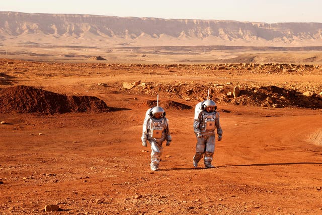 Un par de astronautas de un equipo de Europa e Israel caminan con trajes espaciales durante una misión de entrenamiento para el planeta Marte en un sitio que simula una estación externa en el cráter Ramon en Mitzpe Ramon, en el desierto del Negev, en el sur de Israel, el 10 de octubre. , 2021