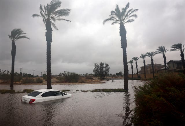 A car is partially submerged in floodwaters as Tropical Storm Hilary moves through the area on August 20, 2023 in Cathedral City