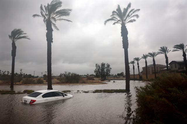 A car is partially submerged in floodwaters as Tropical Storm Hilary moves through the area on August 20, 2023 in Cathedral City