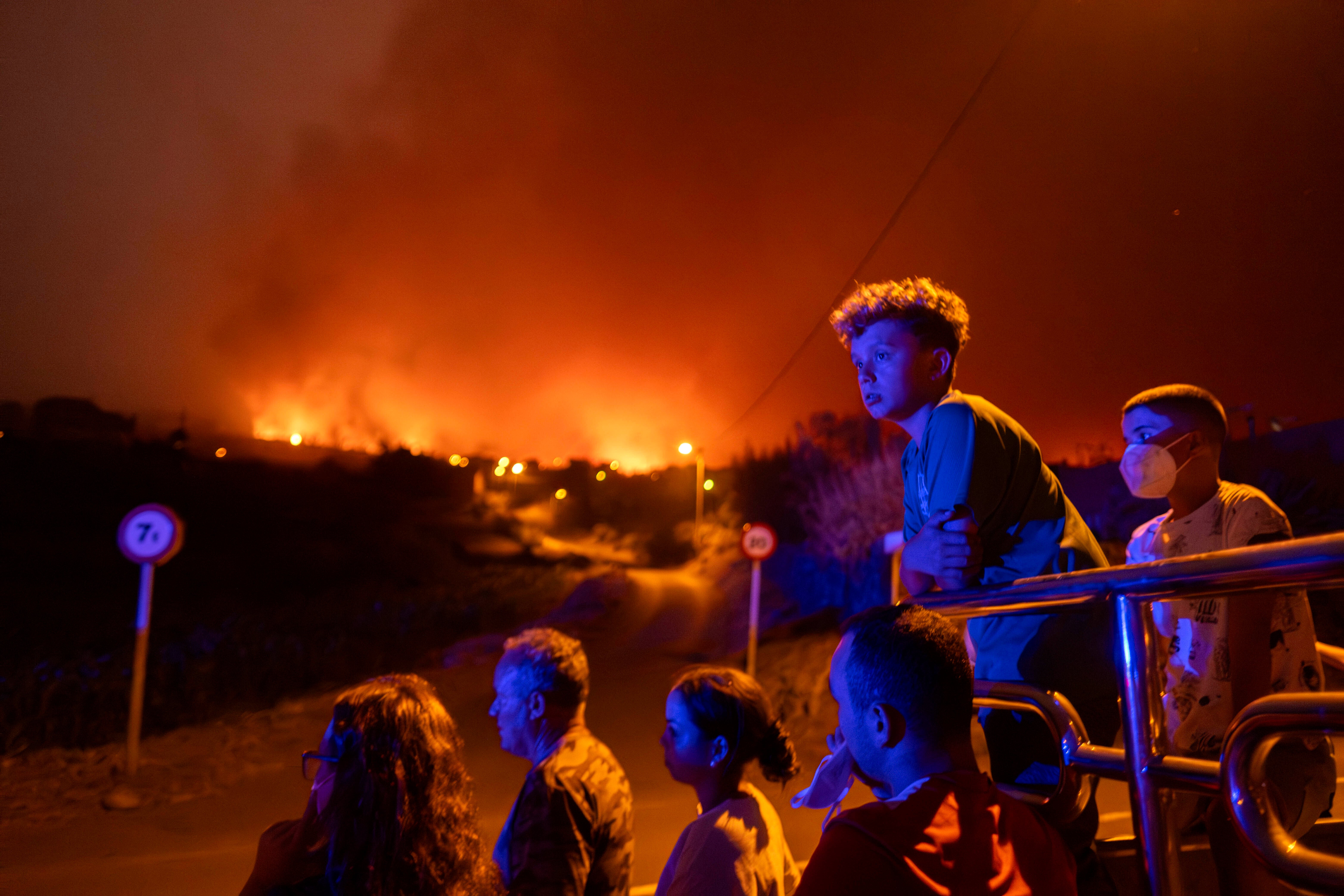 Local residents try to reach their houses in Benijos village as police block the area as fire advances in La Orotava