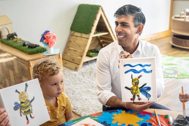 <p>Rishi Sunak shows his painting of a bee at the Busy Bees nursery in Harrogate on Monday</p>