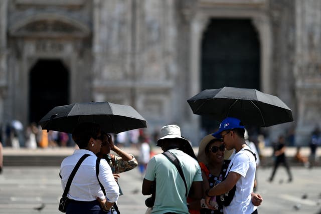 <p>Tourists protect themselves from the heat in Milan amid Europe’s record-breaking heatwave in July. Scientists say at least 1.5 billion people were exposed to extreme heat each day this summer </p>